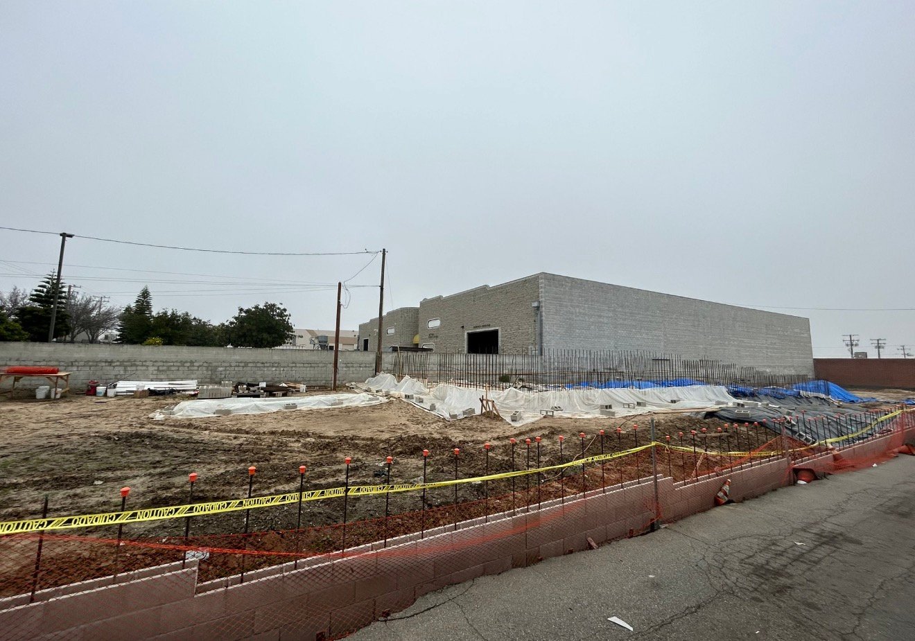 Foundation construction underway beside an existing building
